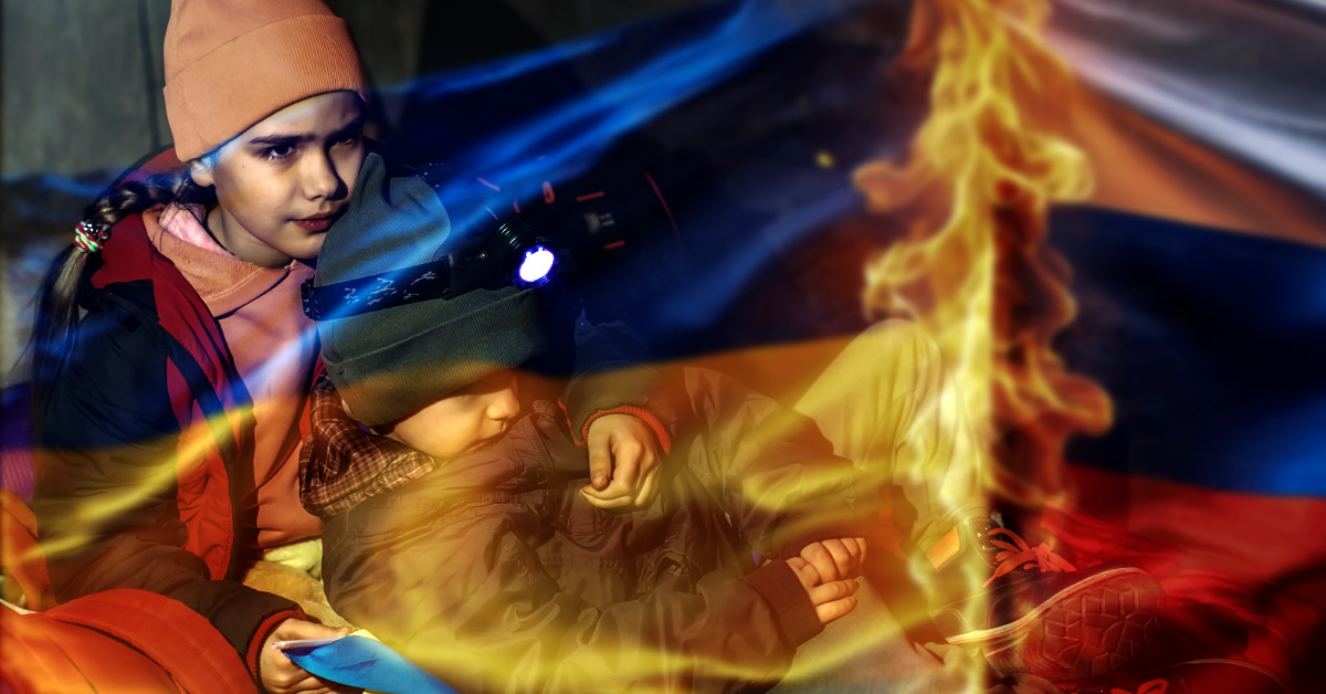 A haunting, high-contrast BZV header image showing two Ukrainian children—an older sister and her small brother—huddled together for warmth in a dark, freezing concrete bunker. They are draped in a blue and yellow Ukrainian flag, the edge of which is singed by a small survival fire. On the opposite side of the flames, a Russian flag lies tattered and burning, symbolizing the scorched-earth reality of the 1,432-day conflict.